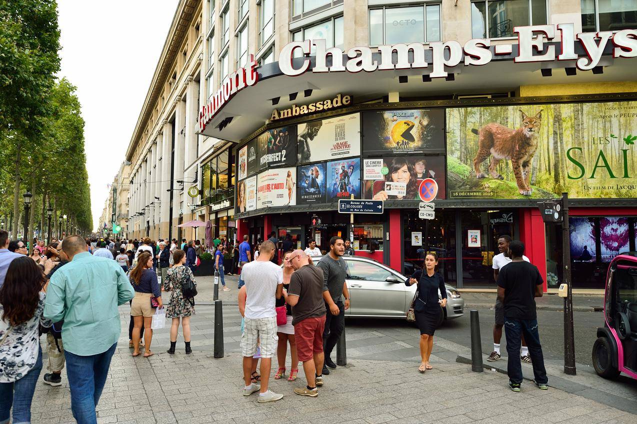 フランスのシャンゼリゼ通りの店の前に立つ大勢の人々。 フランスのシャンゼリゼ通りの店の前に立つ大勢の人々。