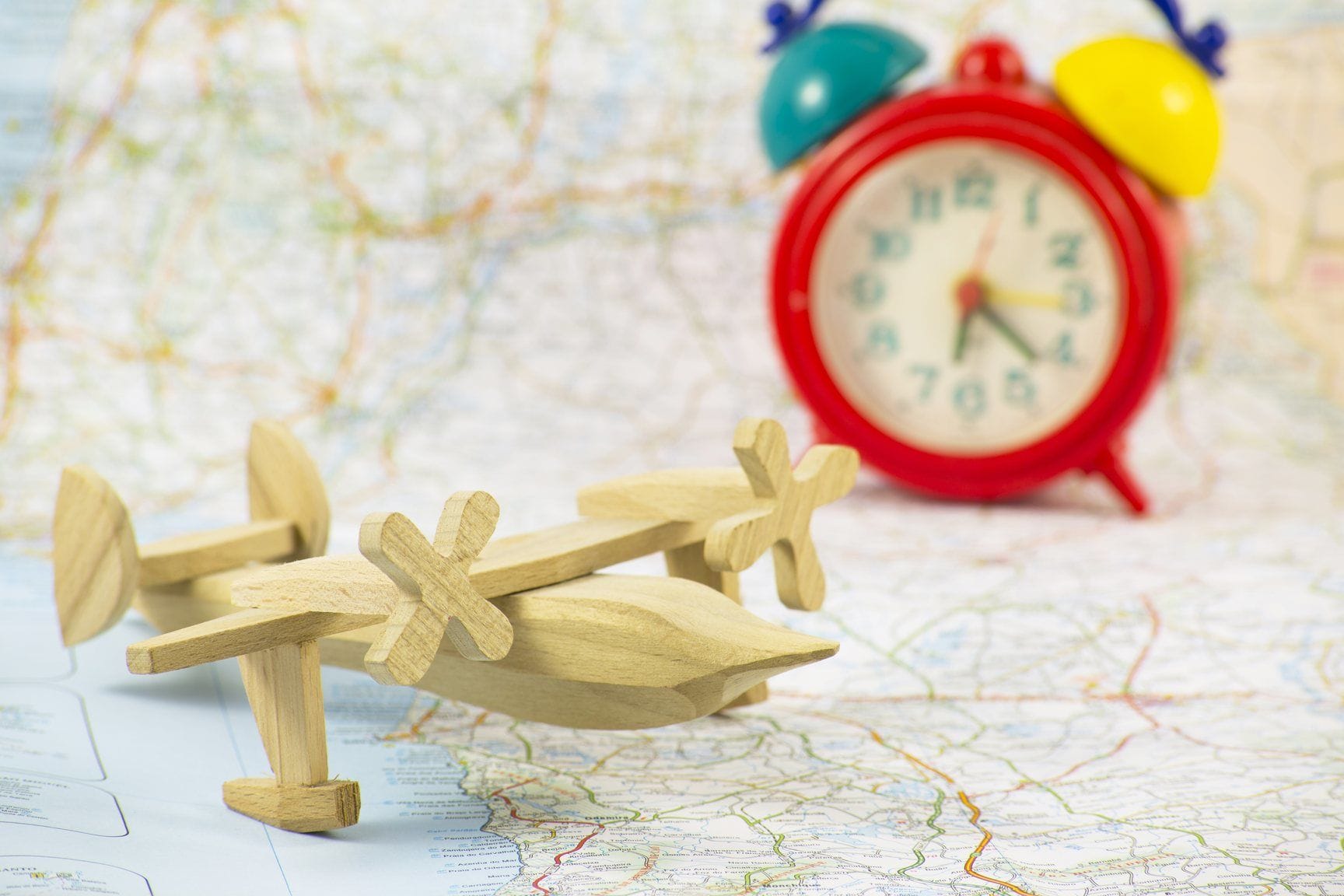 フランス（フランス）をイメージした、目覚まし時計の横にある地図上の木製飛行機。