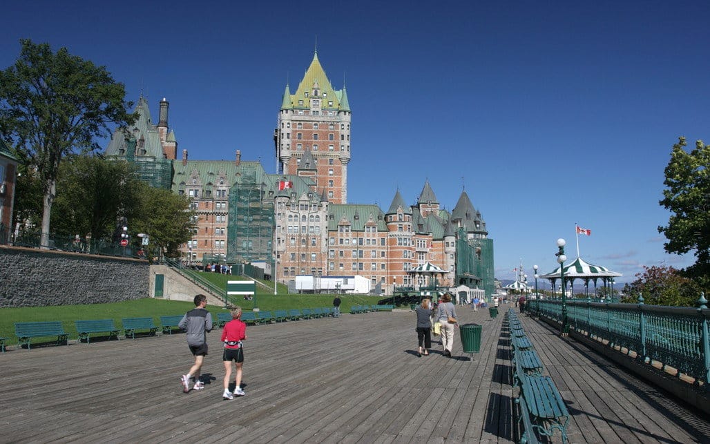 フランスの城の前の遊歩道を歩く人々。
