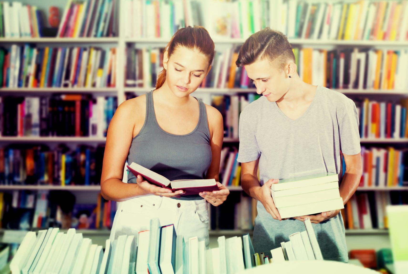図書館でフランス語の本を勉強している 2 人の若者。