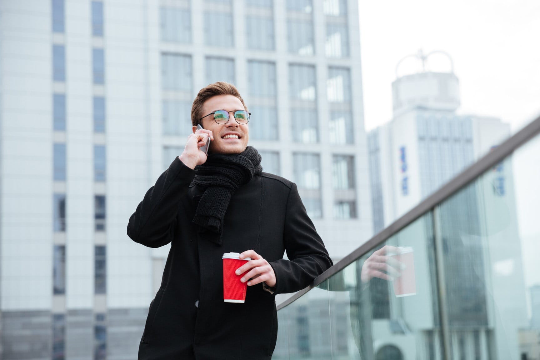 フランスでコーヒーを飲みながら電話で話している男性。