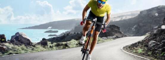 フランスの海の近くの道路を自転車に乗る男性。