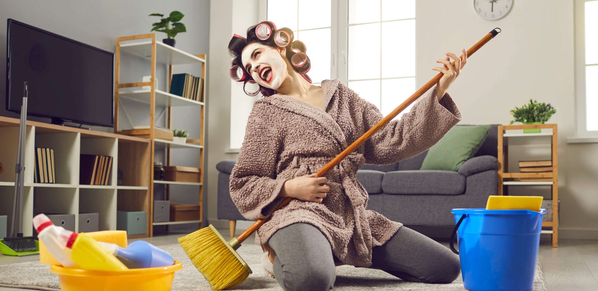 モップとバケツを使ってリビングルームを掃除するフランスの女性。