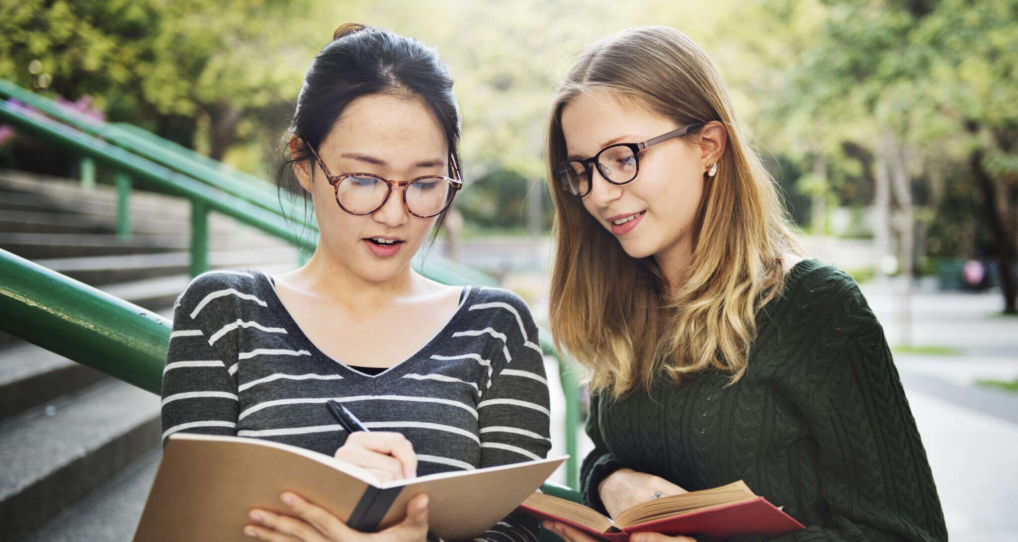 フランスの 2 人の女性が階段に座りながら本を見ています。