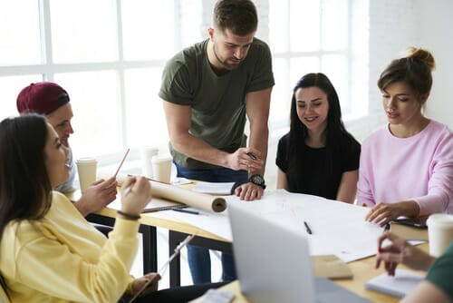 フランスでテーブルを囲んでプロジェクトに取り組む人々のグループ。
