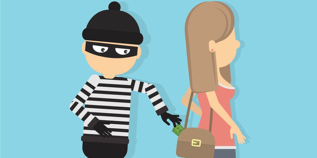 フランスでマスクをした泥棒が女性の財布を握っている。