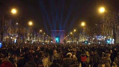 フランスの夜の通りを歩く大勢の人々。