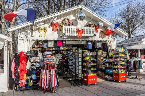 フランス、パリの路上にある服と旗のある店。