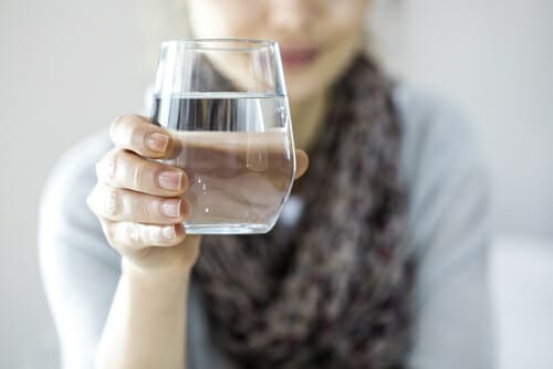 水の入ったグラスを掲げるフランスの女性。