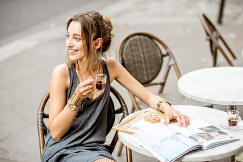 フランスの屋外テーブルに座ってコーヒーを飲む女性。