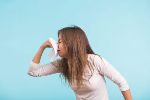 ティッシュで鼻をかむフランスの女性。