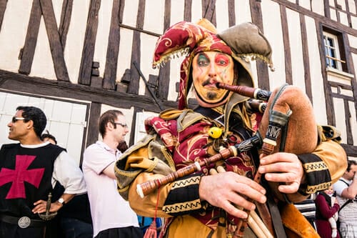 フランスで道化師に扮した男性がパイプを演奏する。