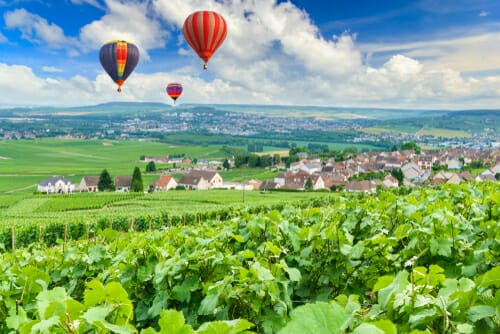 フランスのブドウ畑と村の上空を飛ぶ熱気球。