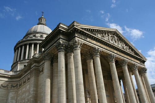 澄んだ青空に向かってそびえ立つ柱がそびえ立つ、フランスにある壮大な建物。