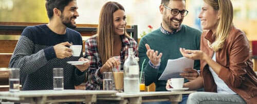 フランスの屋外カフェで会話をする友人のグループ。