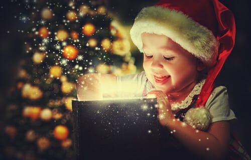 サンタ帽子をかぶった女の子が興奮してクリスマス プレゼントを開けています。

キーワード: サンタ帽子、クリスマス