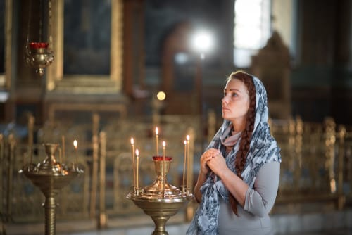 フランスの教会で祈る若い女性。