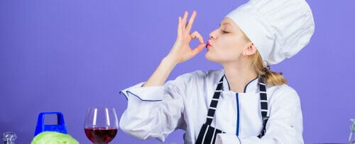 フランス料理をイメージしたシェフハットをかぶった女性が身振り手振りをしている。