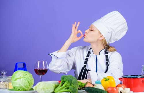 フランス料理をイメージしたシェフハットをかぶった女性が身振り手振りをしている。 フランス料理をイメージしたシェフハットをかぶった女性が身振り手振りをしている。