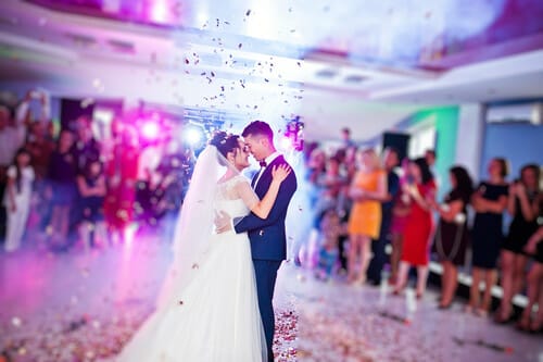 フランスの結婚披露宴で、紙吹雪の前でキスをする新郎新婦。