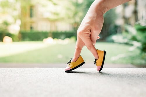 女性の手はフランスから来た小さな靴を持っています。