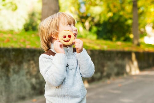 フランスの少年が公園でクッキーを食べています。