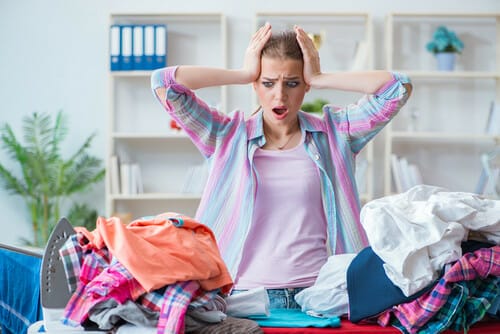 フランスで女性が衣服の山の前に立っています。