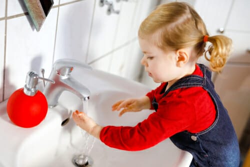 フランスで、小さな女の子が流しで手を洗っています。 フランスで、小さな女の子が流しで手を洗っています。