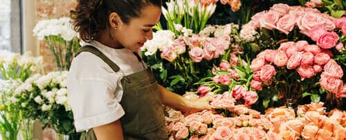 フランスの優雅さをイメージした女性が花屋で花を生けています。