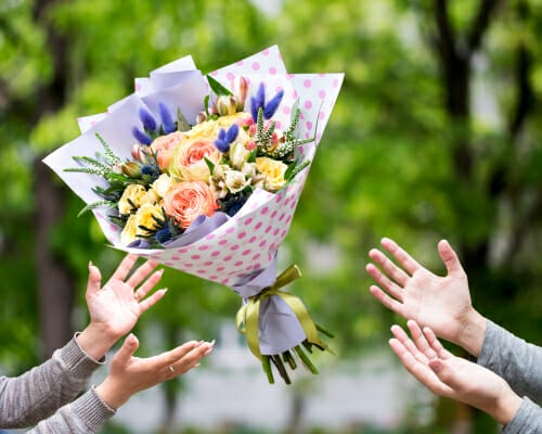 フランスで花束に手を伸ばす両手。