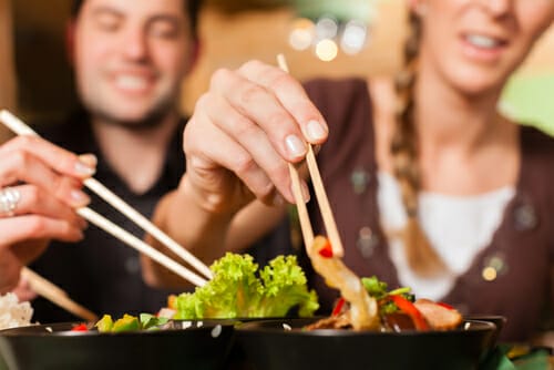 フランス（フランス）でアジア料理を箸で食べる男性と女性。