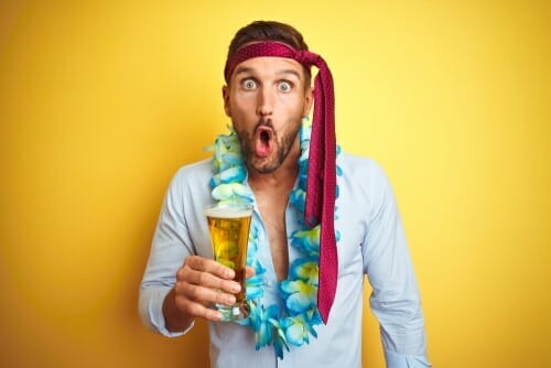 フランスの黄色の背景の前でビールを持っている男性。