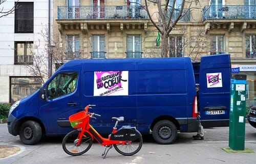 フランスでは、青いヴァンが自転車の前に駐車されています。