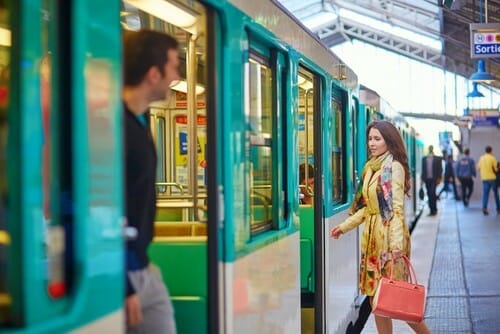 フランスの電車の隣に立つ女性と男性。