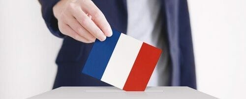 男性がフランス国旗を投票箱に入れています。