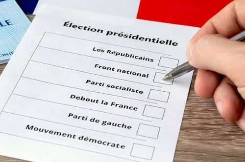 フランスで大統領選挙の投票用紙に記入している人。