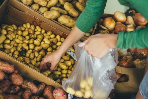 女性が箱からフランス産ジャガイモを取り出している。