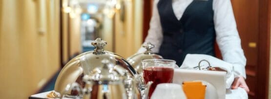 紅茶とコーヒーのトレイを持つフランスのホテルのウェイトレス。