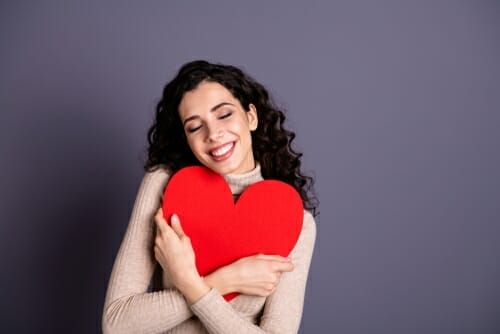 フランスの灰色の背景に赤いハートを持つ女性。