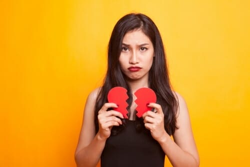 フランスをイメージした、2 つの壊れたハートを手に持つ女性。