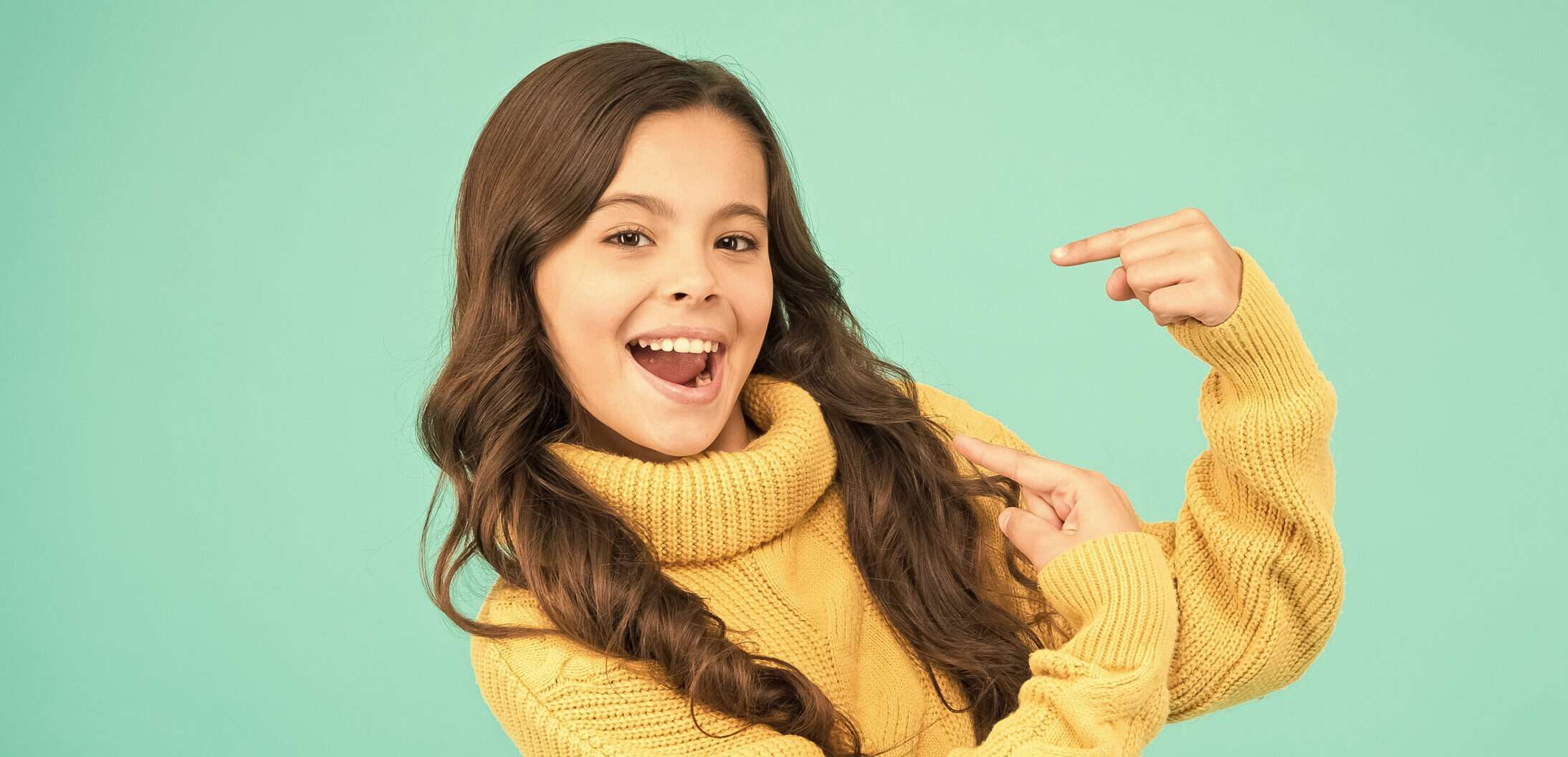 フランスで、緑の背景に若い女の子が指を指差している。