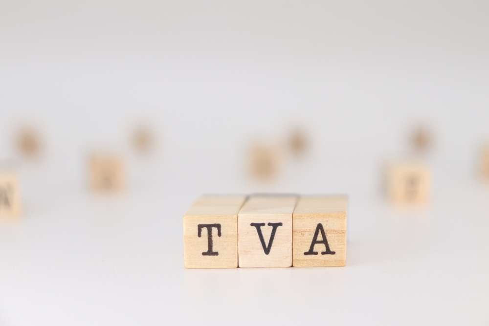 フランスの優雅さを彷彿とさせる、ぼやけた背景に「TVA」の文字が一列に並んだ木製のブロック。