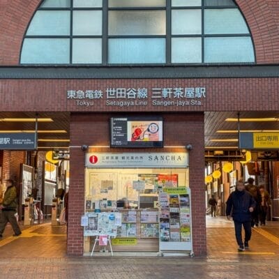 三軒茶屋駅の入口にはにぎやかな切符売り場があり、日本語と英語の看板の下を人々が歩いています。近くには、個人的なフランス語レッスンを求めている人向けのフランス語教室マンツーマンも見つかるかもしれません。.