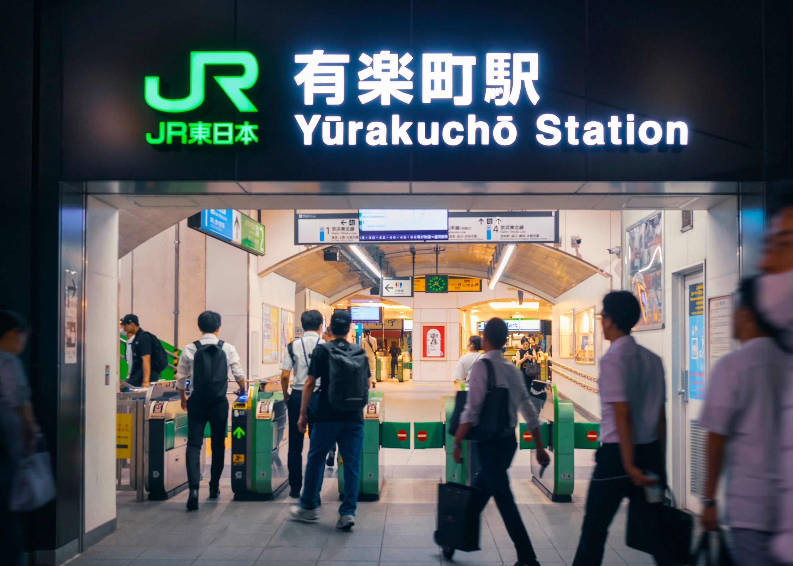 有楽町駅では改札口から出入りする人がいますが、入り口の上には目的地まで案内する標識があります。近くには、この賑やかなエリアでフランス語を学びたい人に、マンツーマンのフランス語教室というユニークな機会を提供しています。.
