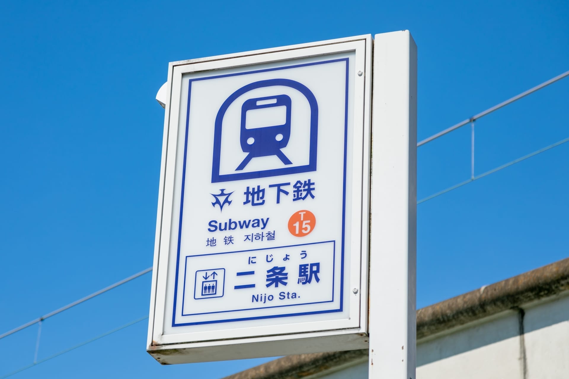 地下鉄のアイコンと日本語、英語、フランス語教室マンツーマンの文字が描かれた二条駅の標識が、澄んだ青空に堂々と立っています。. 地下鉄のアイコンと日本語、英語、フランス語教室マンツーマンの文字が描かれた二条駅の標識が、澄んだ青空に堂々と立っています。.