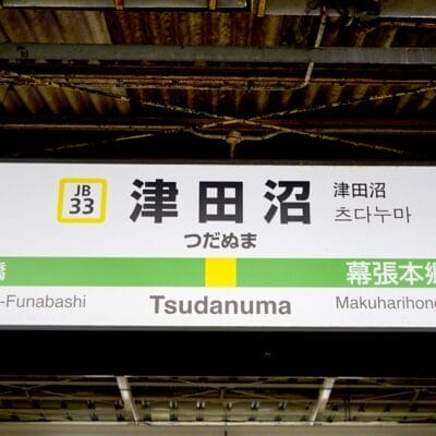 津田沼駅の標識には、駅番号 JB33 と JB34 で東船橋と幕張本郷への方向が表示されており、旅行者がスムーズに道順を見つけることができます。.