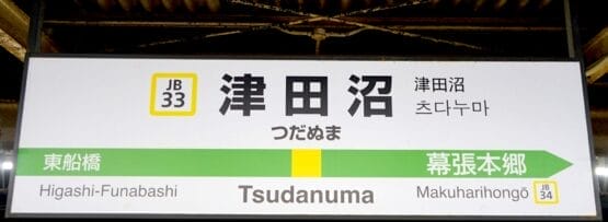 津田沼駅の標識には、駅番号 JB33 と JB34 で東船橋と幕張本郷への方向が表示されており、旅行者がスムーズに道順を見つけることができます。.