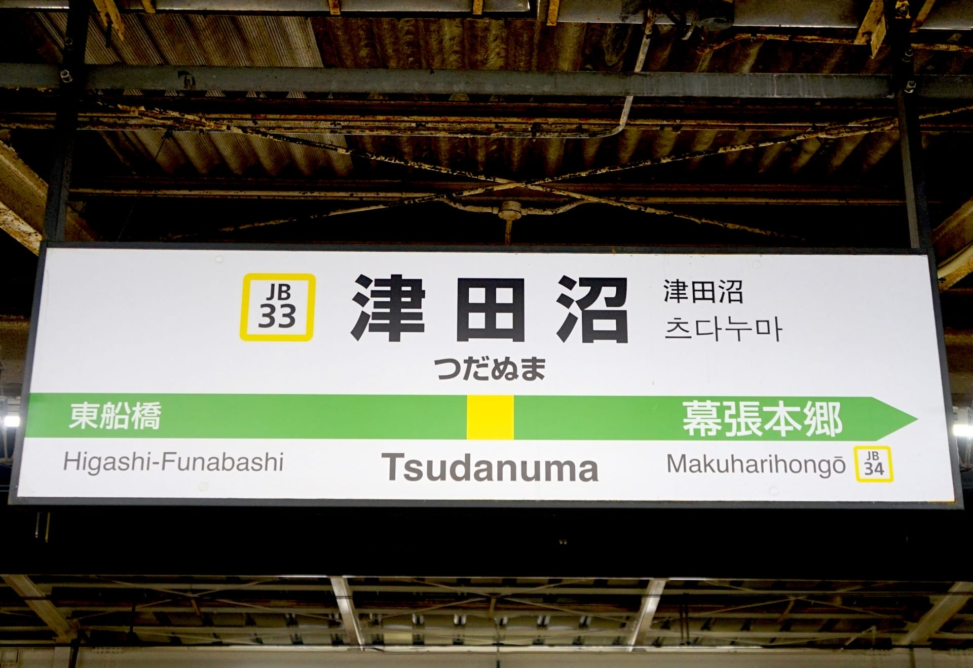 津田沼駅の標識には、駅番号 JB33 と JB34 で東船橋と幕張本郷への方向が表示されており、旅行者がスムーズに道順を見つけることができます。.