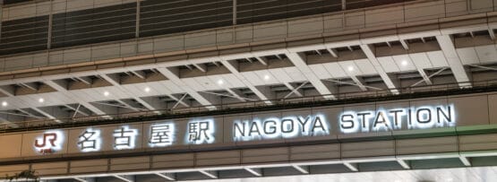 賑やかな名古屋駅の入り口には、日本語と英語の照明付き看板があり、タクシーが並んでいます。近くには、マンツーマンでフランス語を学びたい人のために、フランス語の個人レッスンを提供するフランス語教室マンツーマンがあります。.