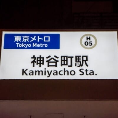 東京メトロの神谷町駅の標識は、駅コード「H 05」と日本語と英語の文字が併記されており、近くの神谷町フランス語教室マンツーマンセッションに参加する通勤者にとって便利なスポットとなっています。.